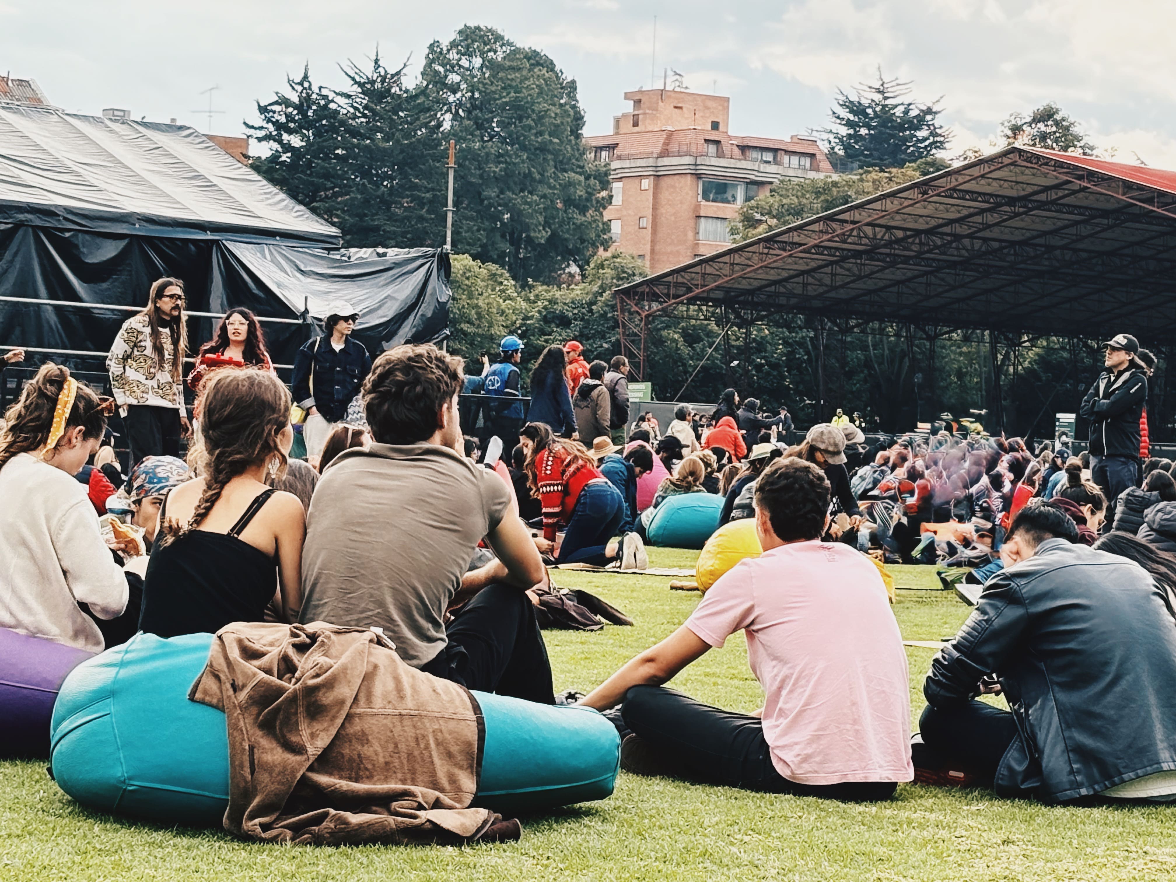 Varias personas sentadas en el piso viendo un evento cultural