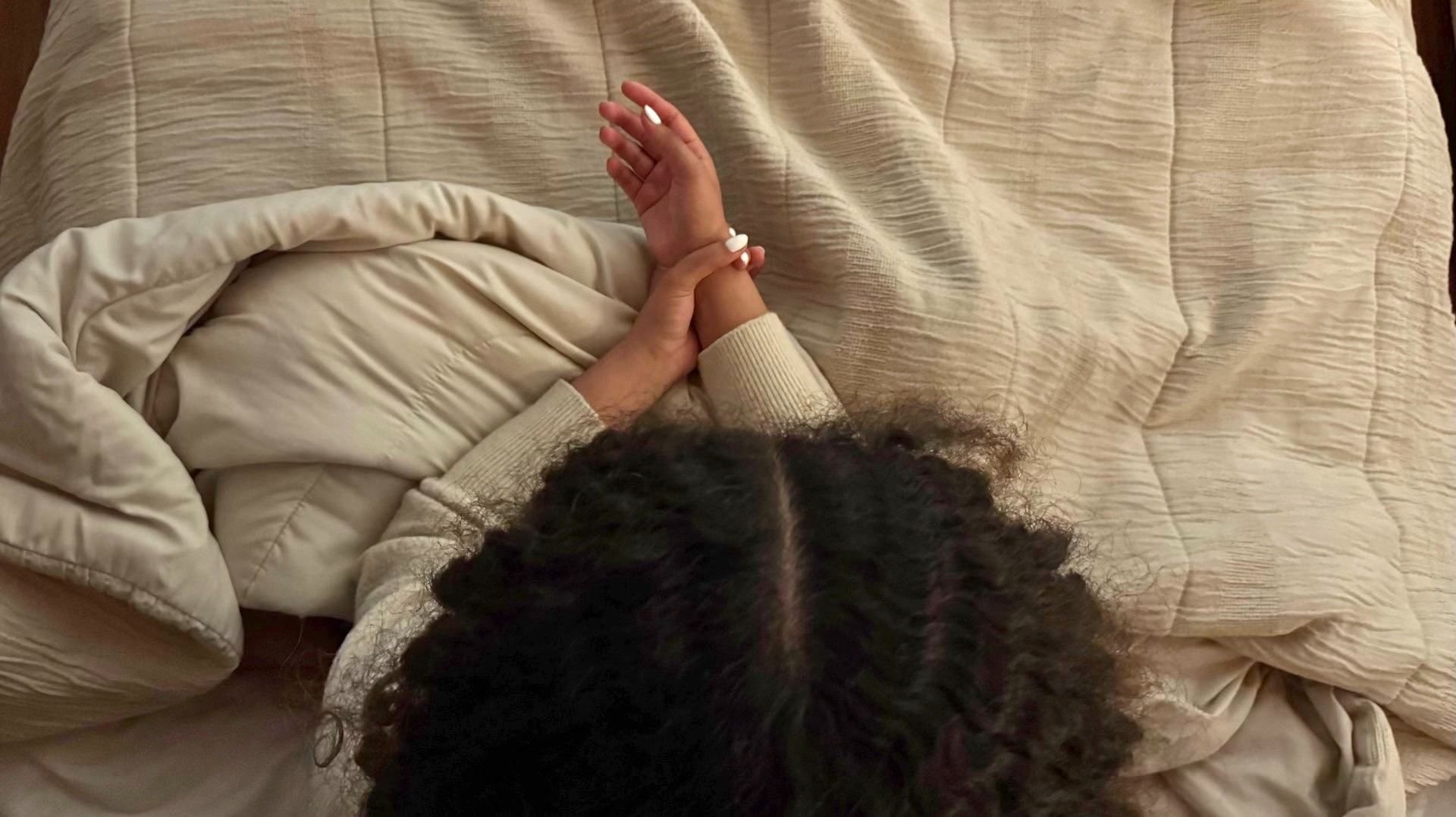 Persona acostada en la cama mide su muñeca con dos dedos para comprobar cuánto ‘sobra’, gesto asociado a trastornos alimenticios en jóvenes en Colombia.