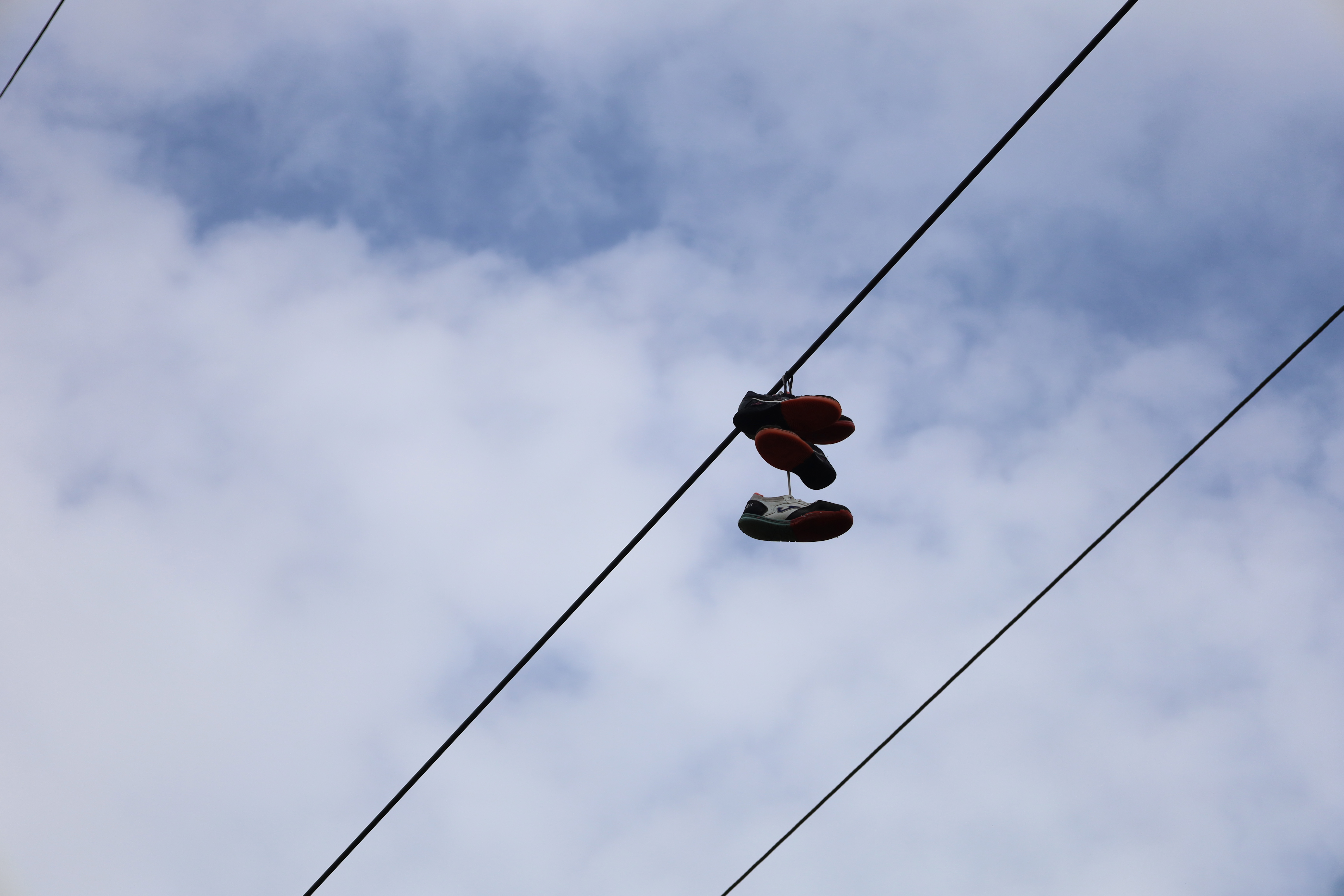 Zapatos deportivos colgados en cables de alta tensión