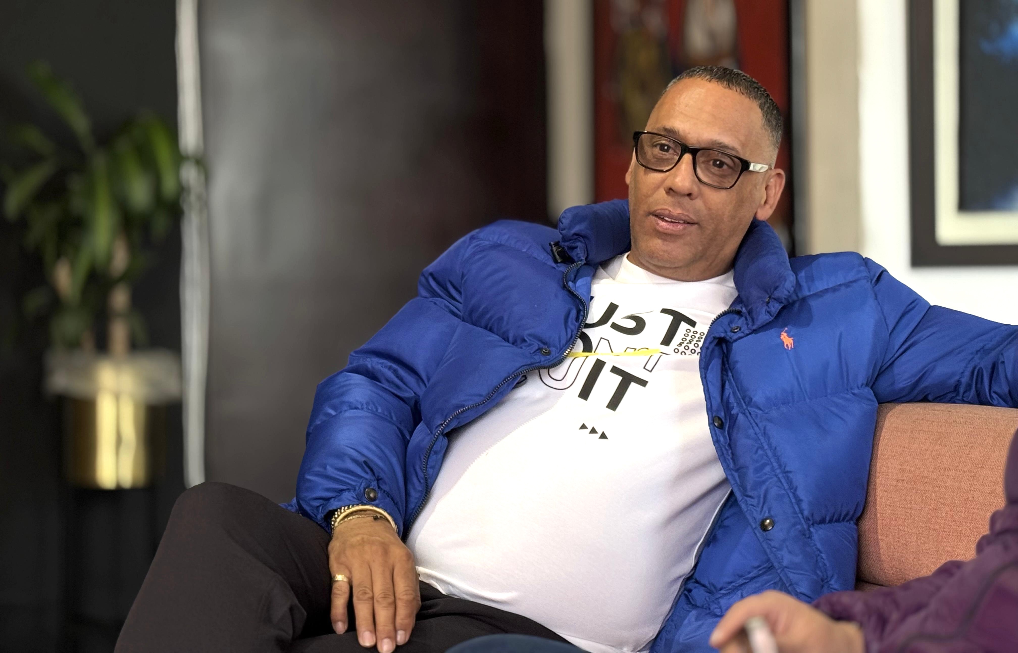 Hombre con chaqueta azul sentado en un mueble