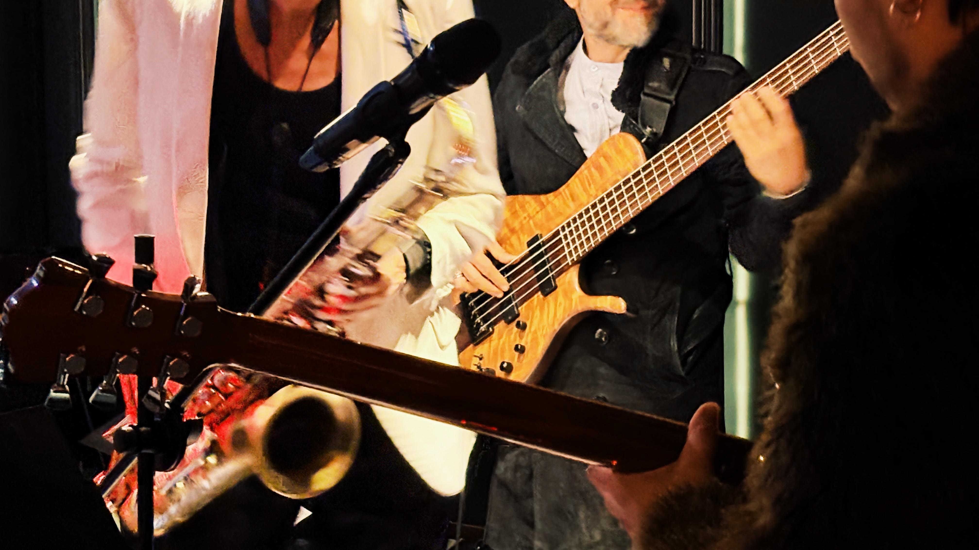 Tres personas sosteniendo un saxofón, guitarra y bajo