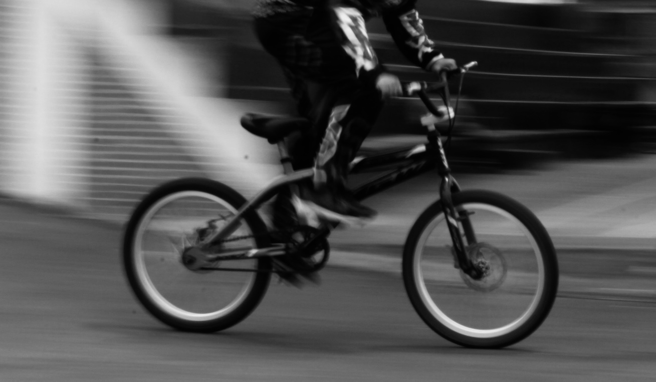 Imagen de un joven en bicicleta en movimiento. Foto a blanco y negro