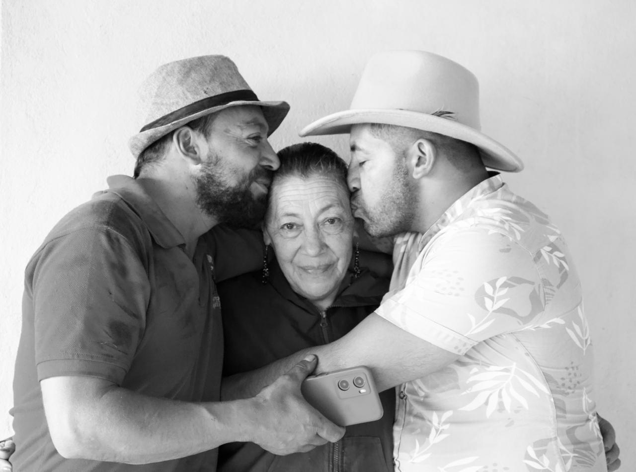 Mery, protagonista de la historia, junto a dos de sus hijos besándola en la cabeza.