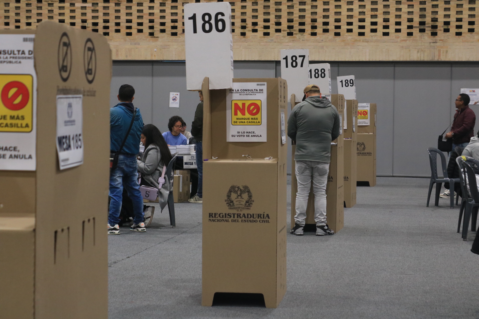 Puestos de votación y gente votando 