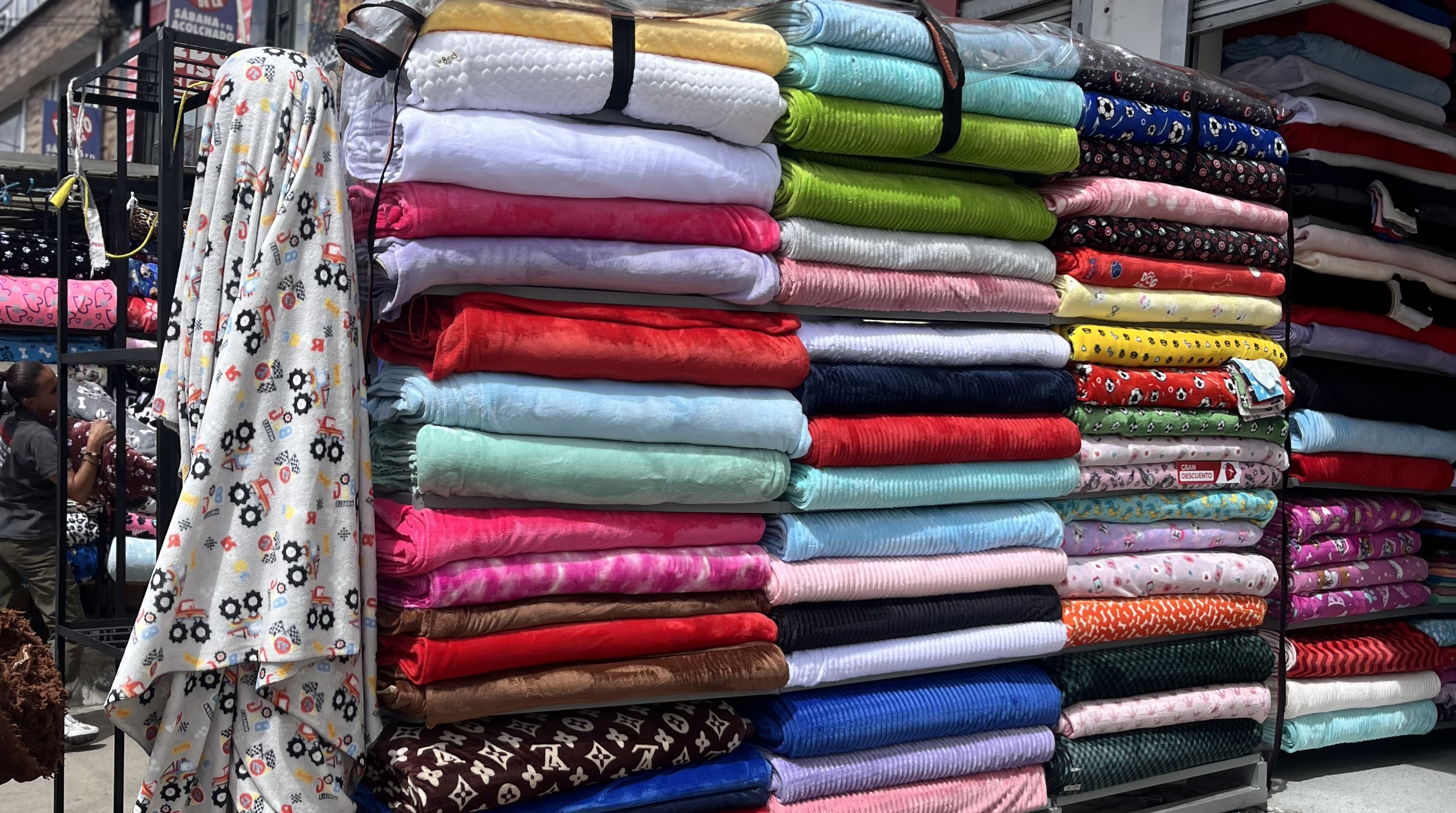 Rollos de tela exhibidos en un local de La Alquería, Bogotá. La oferta de insumos textiles convive con una caída en la demanda de confección local.